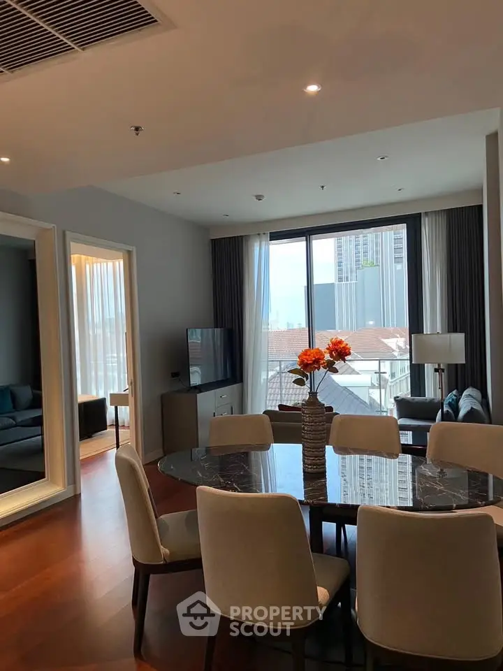 Luxurious modern living room with elegant dining area and city view, featuring stylish furniture and decor.