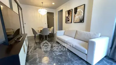 Elegant living room with marble flooring, modern chandelier, and stylish decor.