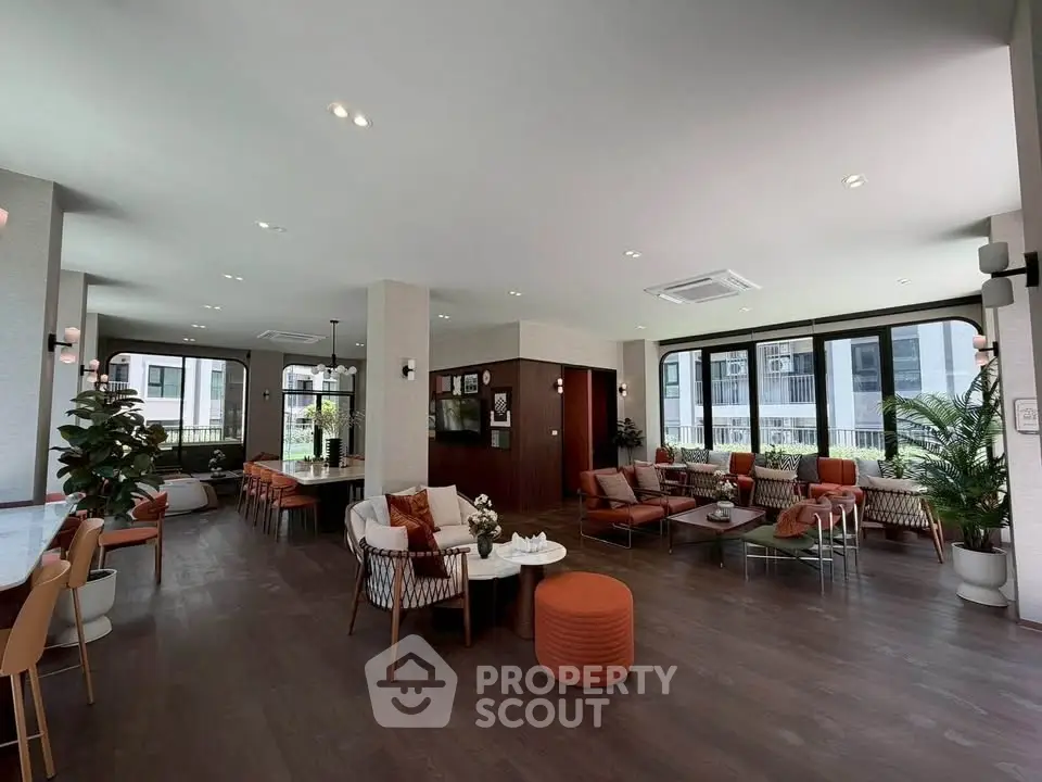 Spacious modern living room with elegant decor and large windows offering natural light.