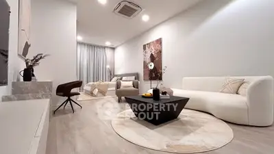 Modern living room with stylish furniture and elegant decor, featuring a cozy seating area and contemporary art.