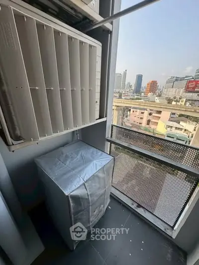 Urban balcony with city view and air conditioning unit, ideal for compact living spaces.