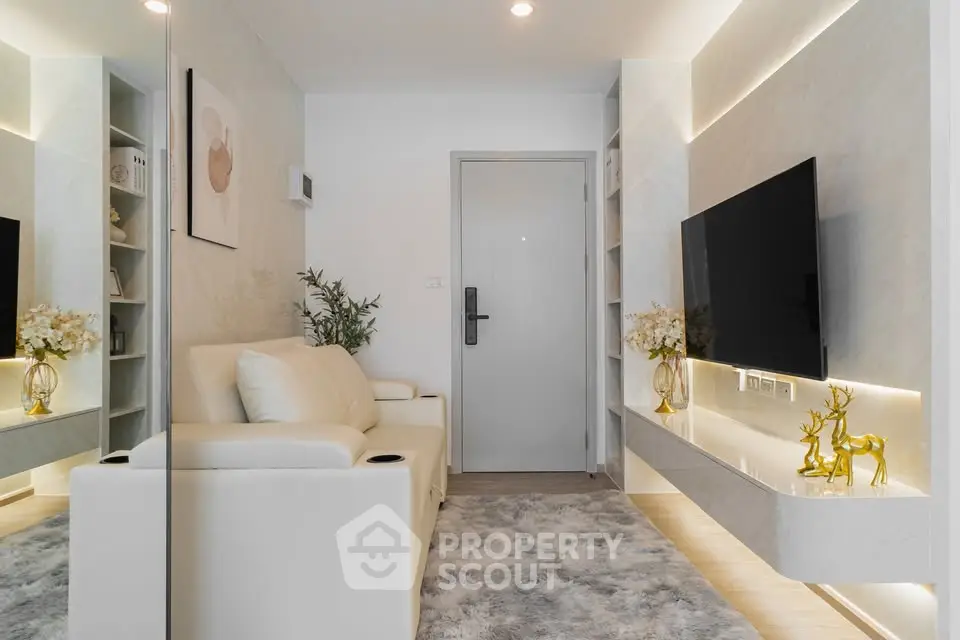 Modern living room with sleek design, featuring a wall-mounted TV, plush white sofa, and elegant decor.