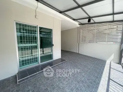 Spacious tiled patio area with sliding glass door and privacy screen.