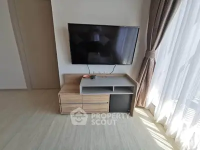 Modern living room with wall-mounted TV and elegant curtains