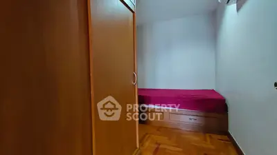 Cozy bedroom with wooden wardrobe and single bed, perfect for minimalist living.