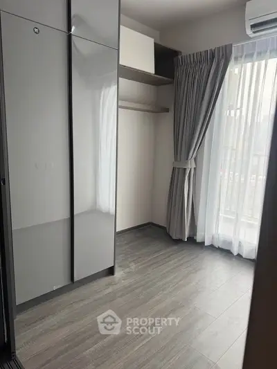 Modern bedroom with sleek closet and large window for natural light