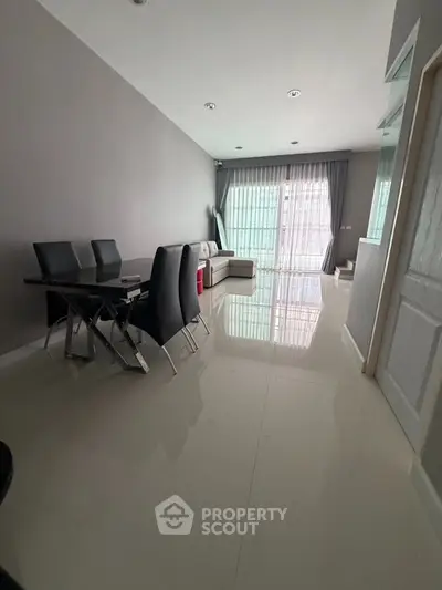 Spacious modern living room with sleek dining area and large windows for natural light.