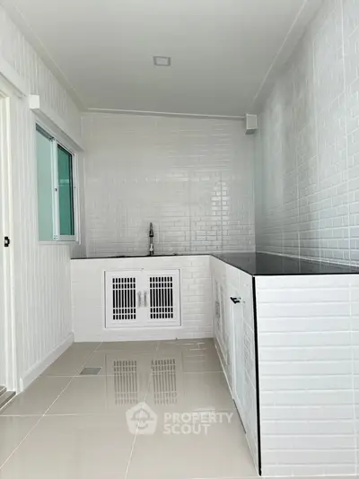 Modern minimalist kitchen with sleek white tiles and built-in sink