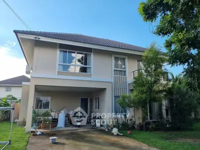 Charming two-story house with lush greenery and spacious driveway in a serene neighborhood.