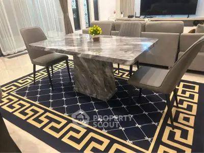 Elegant dining area with marble table and stylish chairs on a patterned rug, perfect for modern living.