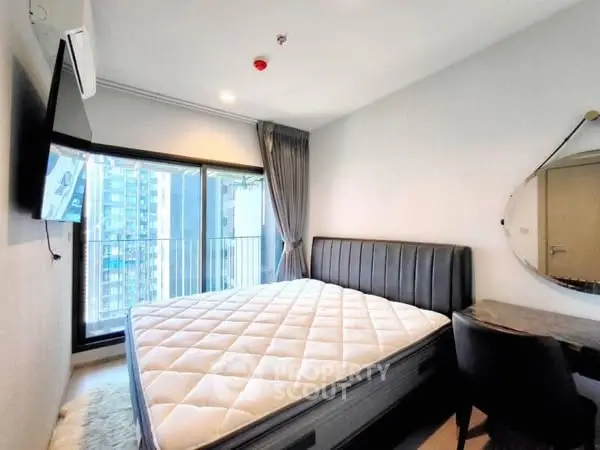 Modern bedroom with city view, featuring a stylish bed and wall-mounted TV.