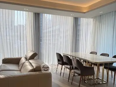 Luxurious modern living room with elegant dining area and floor-to-ceiling windows.