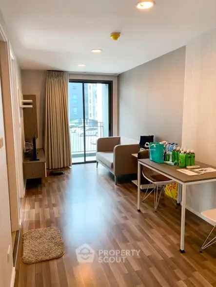 Modern living room with balcony access and stylish furniture in a cozy apartment.