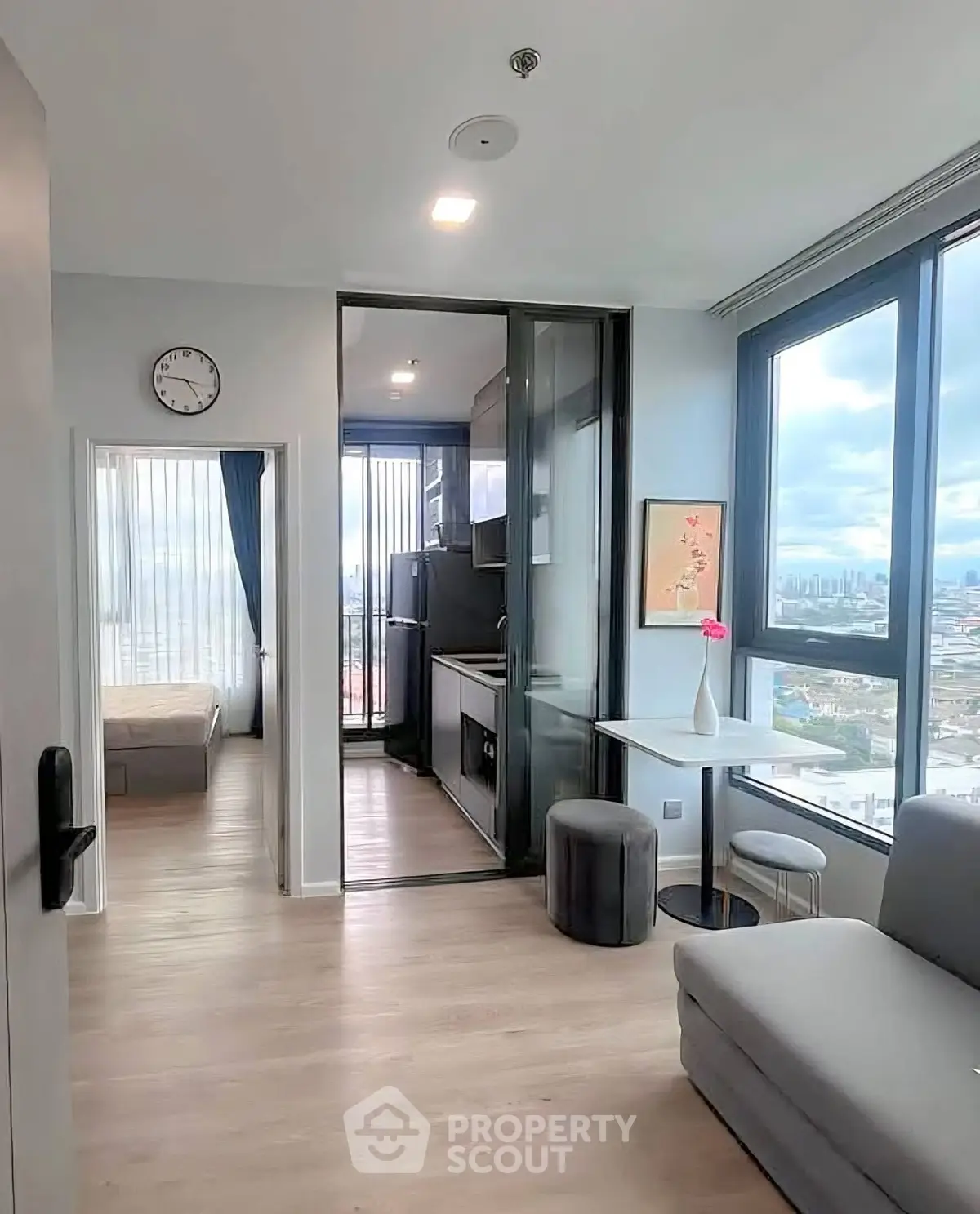 Modern apartment with open layout, featuring a cozy living area, compact kitchen, and stunning city views.