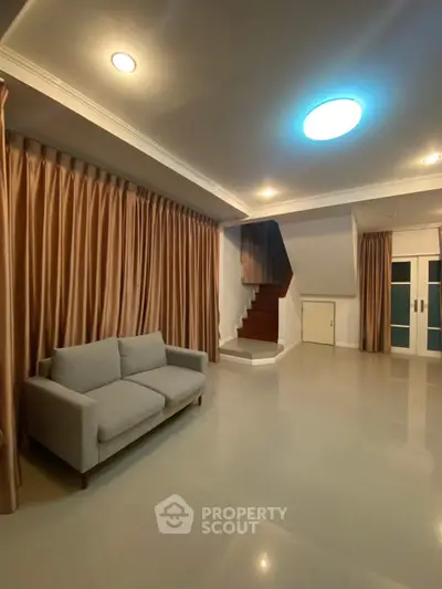 Spacious living room with modern sofa and elegant staircase in a stylish home