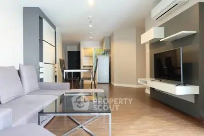 Modern living room with sleek furniture and open kitchen layout in a stylish apartment.