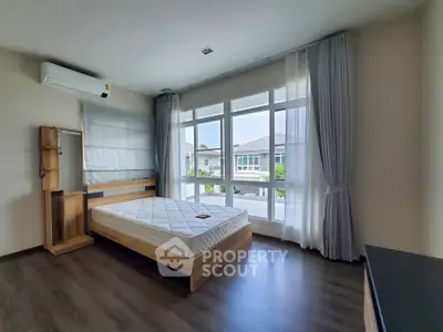 Bright bedroom with large windows and modern furnishings in a stylish home.