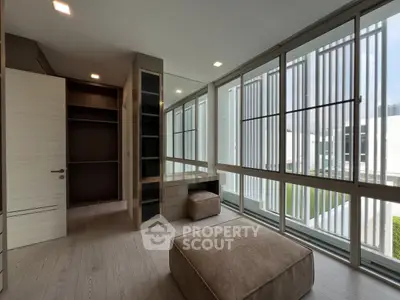 Spacious modern room with large windows and built-in storage