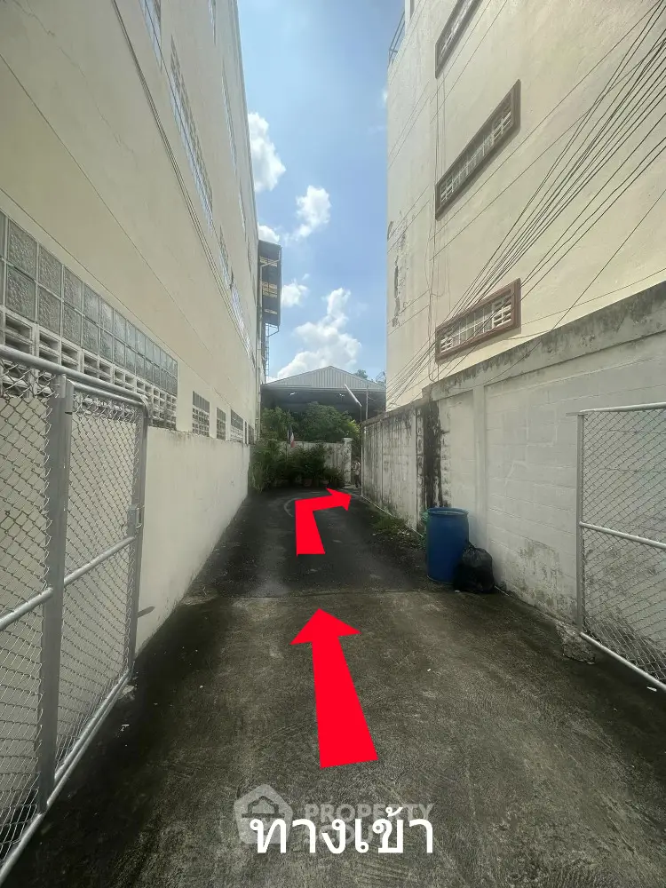 Narrow alleyway between buildings leading to a residential entrance