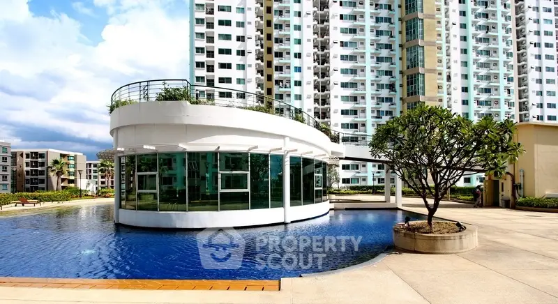 Modern apartment complex with unique poolside architecture and lush landscaping.