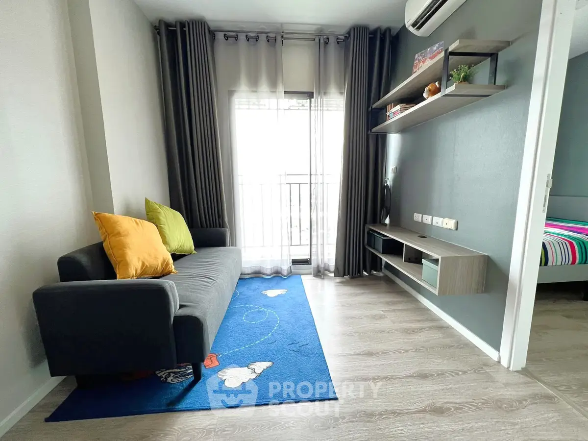 Modern living room with stylish sofa, vibrant rug, and sleek shelving in a cozy apartment.