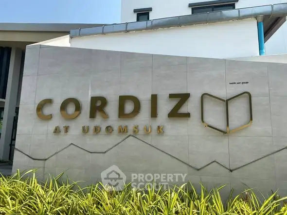 Modern building entrance with Cordiz at Udomsuk signage and lush greenery.