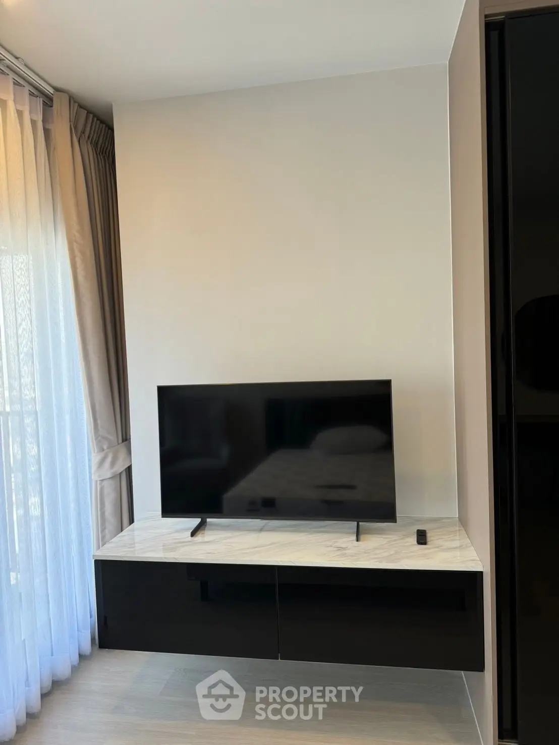 Modern living room with sleek TV setup and elegant curtains