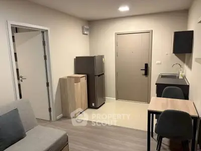 Modern compact studio apartment with kitchenette and cozy seating area.