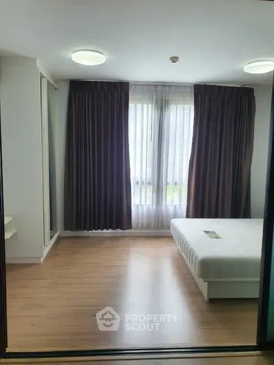 Modern bedroom with large window and wooden flooring