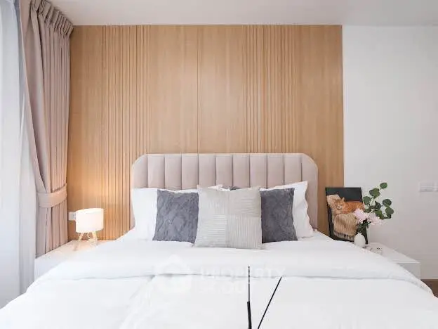 Elegant bedroom with plush headboard and modern decor, perfect for relaxation and comfort.