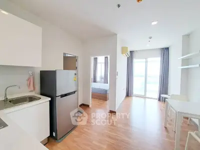 Modern apartment interior with kitchen, dining area, and bedroom view