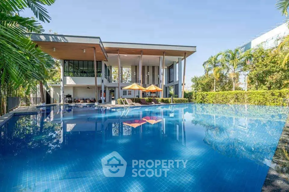Luxurious modern building with stunning pool and lush greenery, perfect for relaxation and leisure.