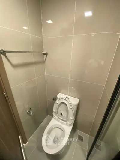 Modern bathroom with sleek tile design and contemporary toilet fixture.