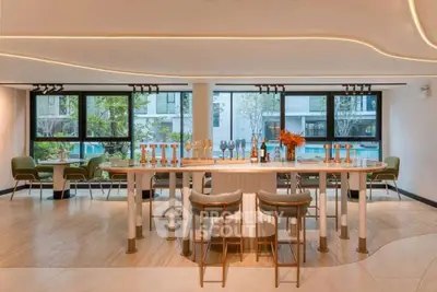 Luxurious modern living room with elegant bar area and large windows overlooking greenery.