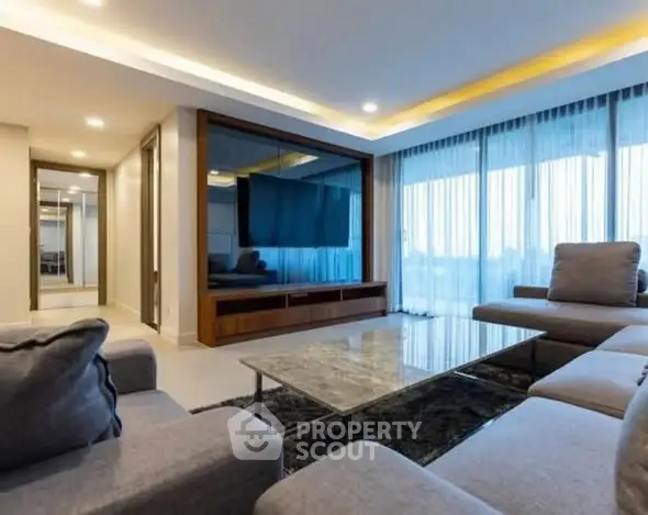 Spacious modern living room with large sectional sofa and sleek TV unit
