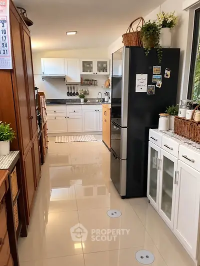 Charming kitchen with modern appliances and stylish decor, featuring a sleek fridge and ample storage space.