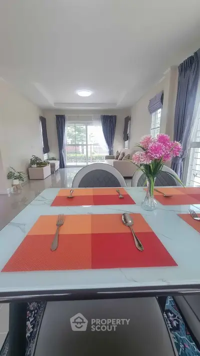 Elegant dining area with modern decor and large windows in a spacious living room.