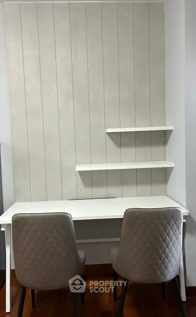 Modern study area with sleek white desk and two stylish chairs, perfect for productivity.