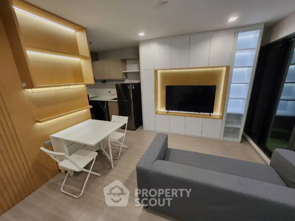 Modern living room with sleek furniture and built-in TV unit in contemporary apartment.