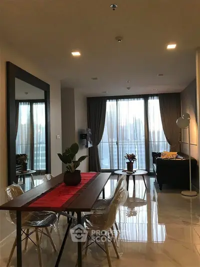Modern living room with elegant dining area and large windows offering natural light.