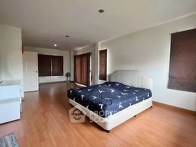 Spacious bedroom with modern decor and large windows for natural light.