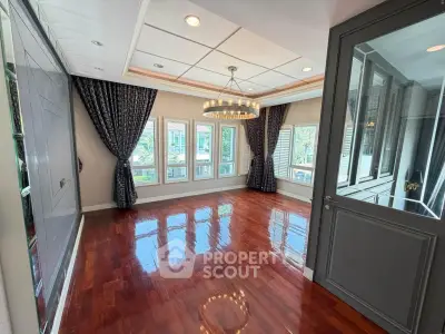 Elegant empty room with polished wooden floors and large windows, perfect for customization.