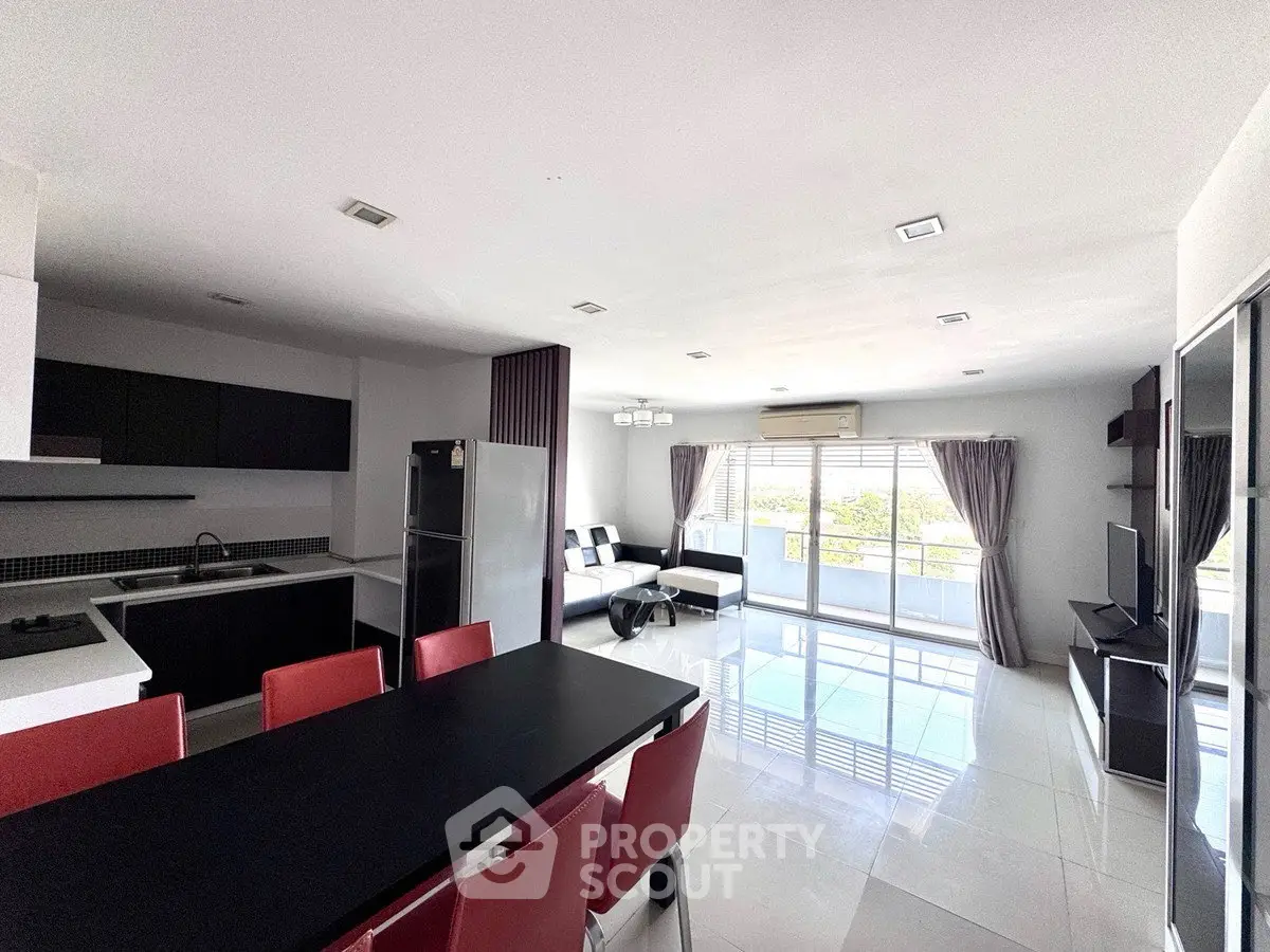 Spacious modern living room with open kitchen and large balcony view