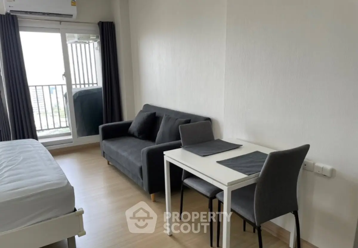 Modern studio apartment with cozy living area and balcony access