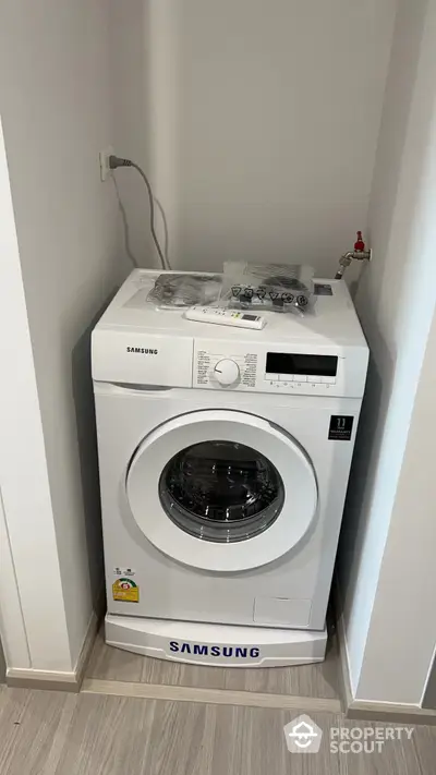 Sleek Samsung washing machine in a modern laundry nook with convenient shelving and easy access, perfect for efficient home management.