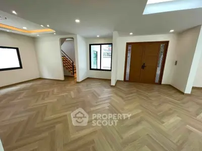 Spacious modern living room with elegant wooden flooring and stylish staircase
