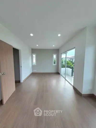 Spacious modern living room with large windows and balcony access