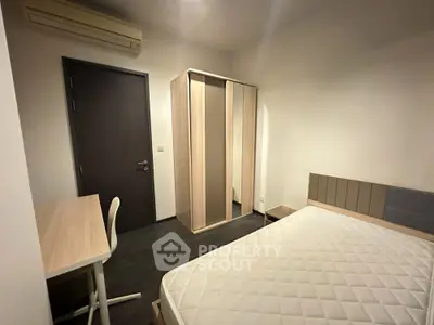 Modern minimalist bedroom with ample natural light, featuring a large bed, built-in wardrobe, and a cozy study area, ideal for urban living.