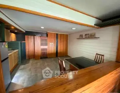 Spacious open-plan kitchen and dining area with modern wooden accents and sleek design.