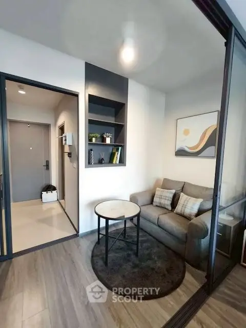 Modern living room with cozy sofa and stylish decor in a compact apartment.